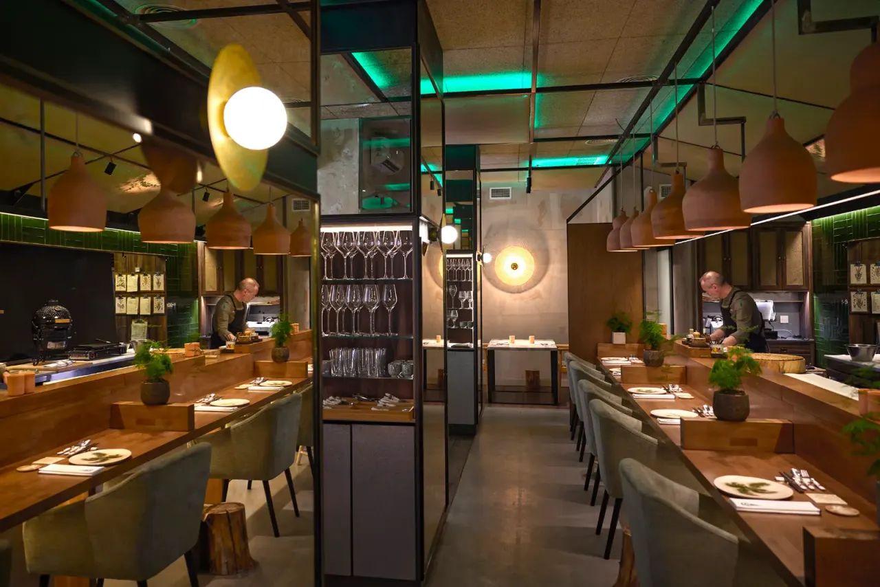 The dining room aisle with the glasses set on the tables and the glassware at the back