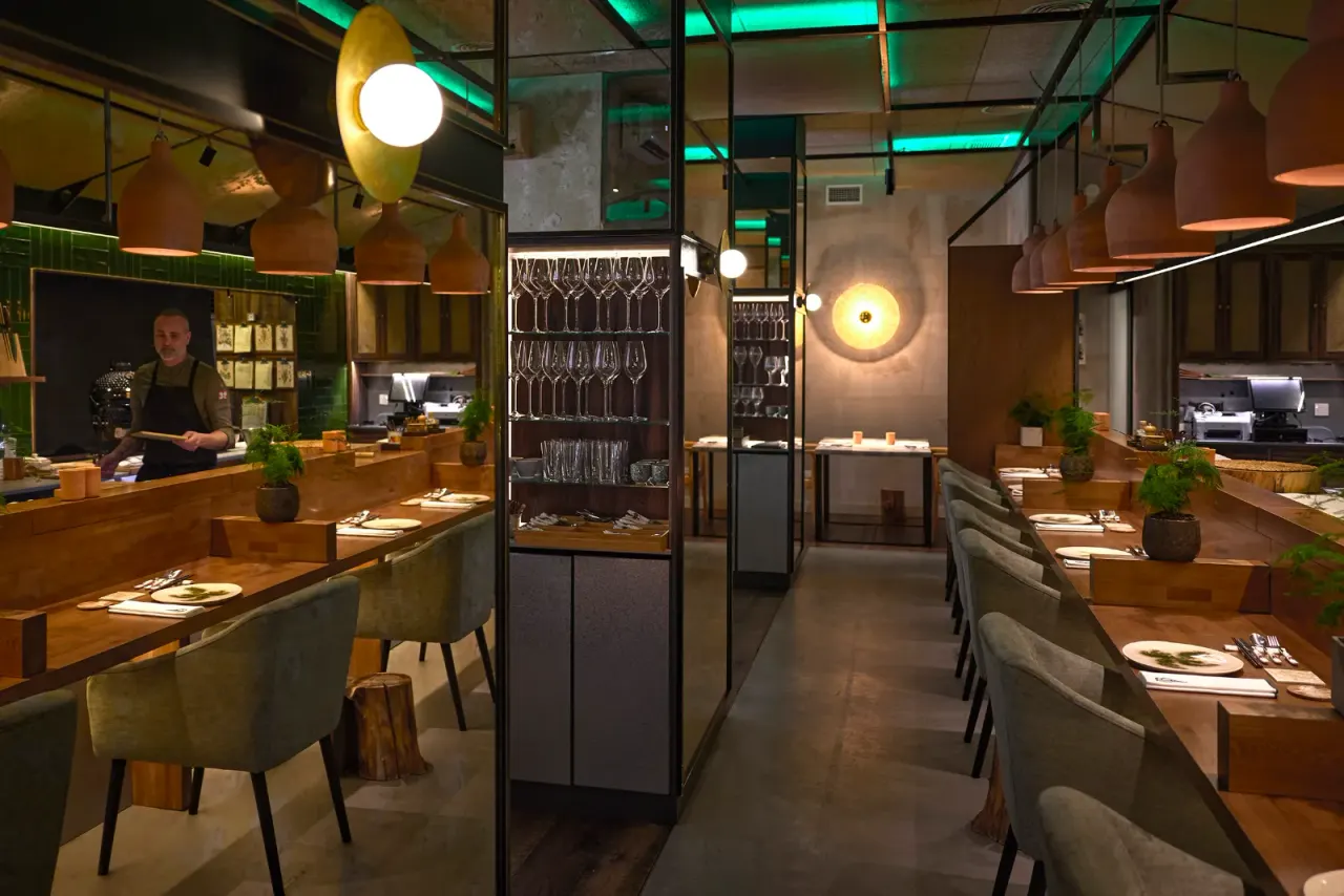 Full view of the dining room at El Invernadero, with the green latticework of the room