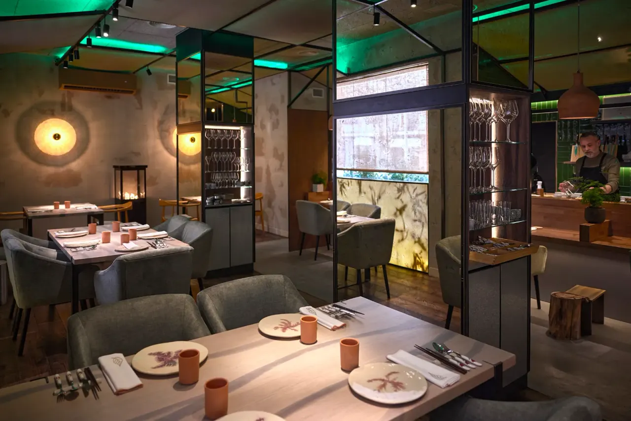 The dining room at El Invernadero with the tables laid and window light at the back