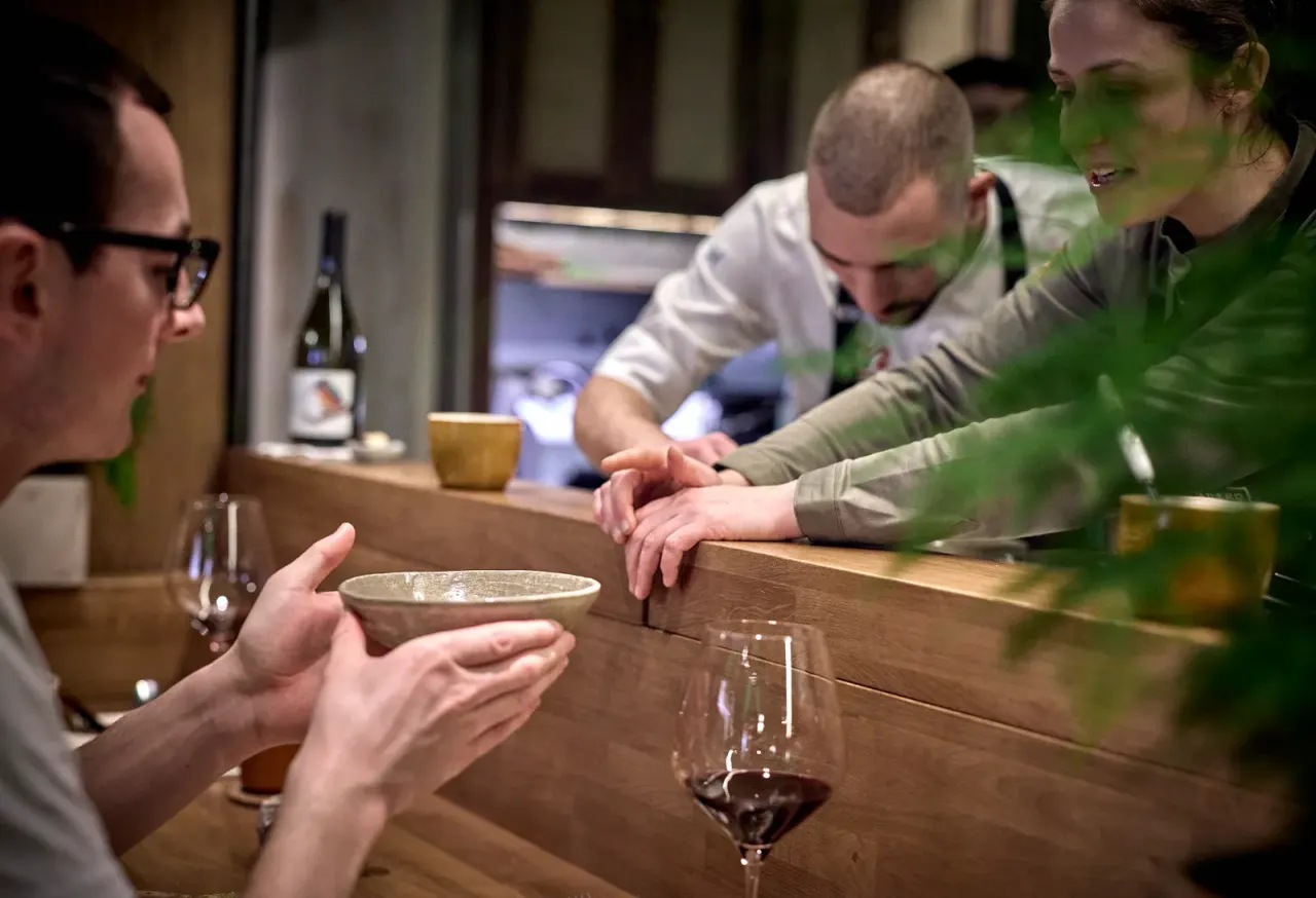 Two diners at the counter of El Invernadero during dinner service