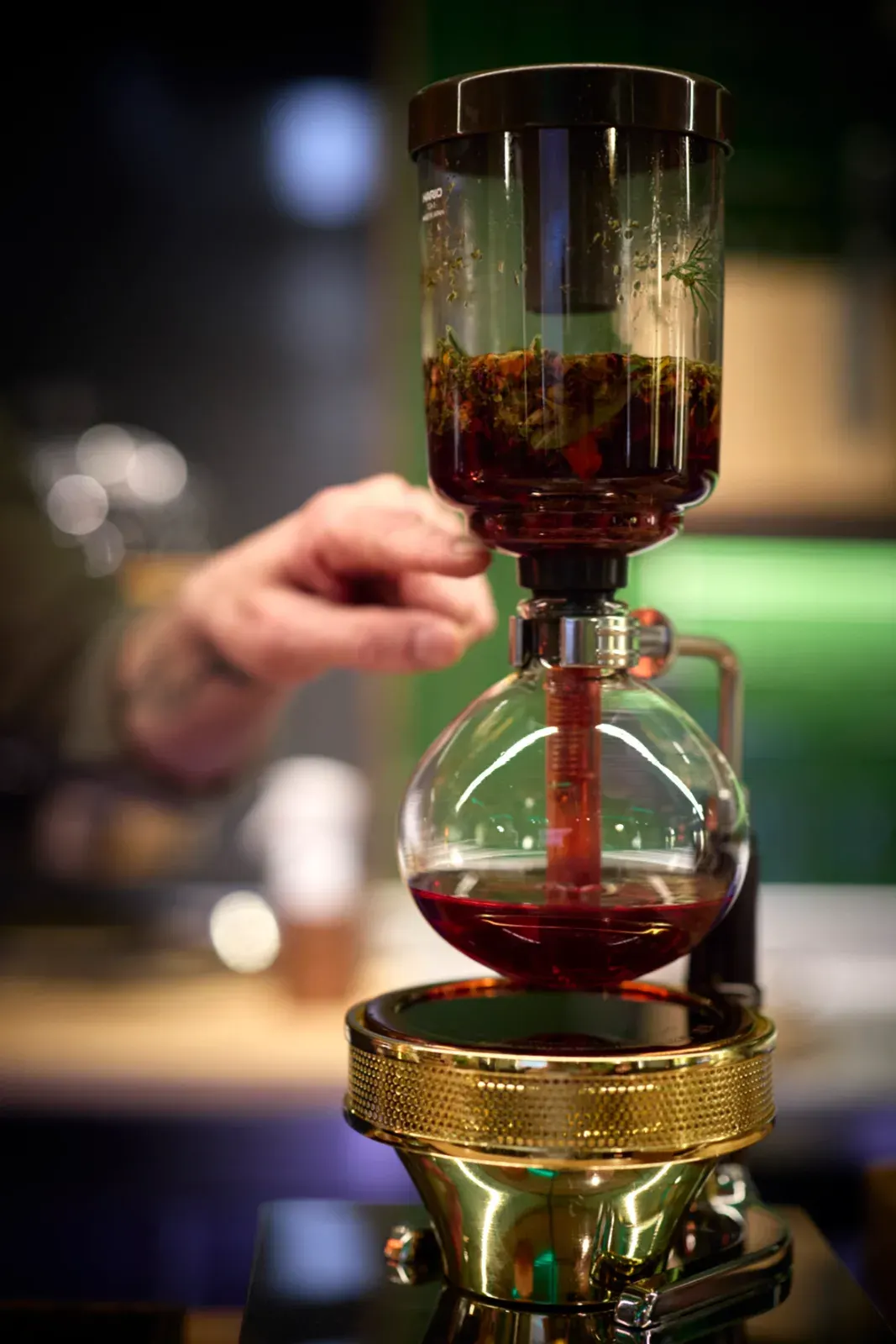 The infusion falling into the glass bulb of the siphon during service