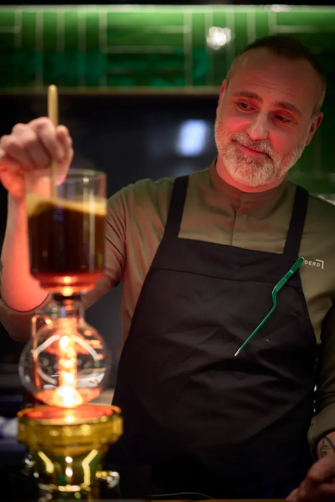 Rodrigo de la Calle preparing an infusion in the siphon, at the counter of El Invernadero